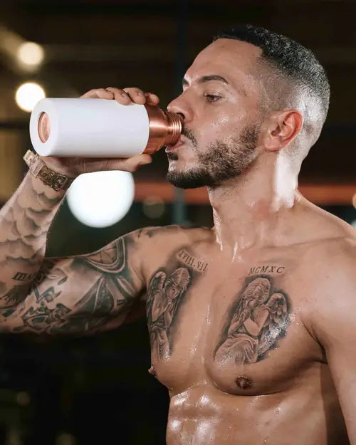 Man drinking water from copper water bottle
